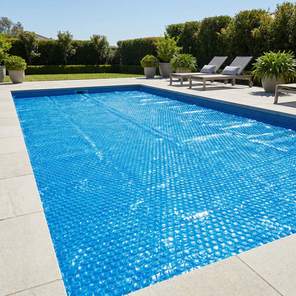 Manta térmica de burbujas azul cubriendo toda la superficie de una piscina